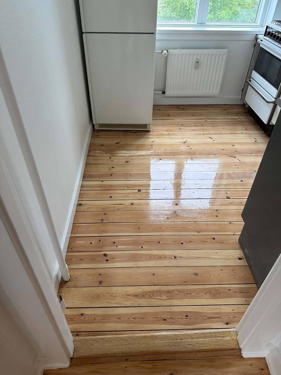 Efter: blankt, lakeret plankegulv i køkken